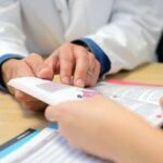 Doctor showing booklet to patient 733x450 1